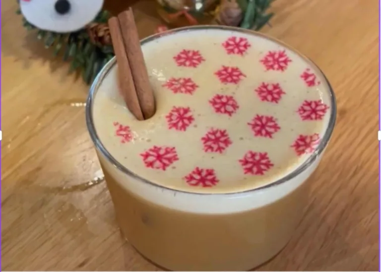Foam-topped winter drink with snowflake print and cinnamon stick